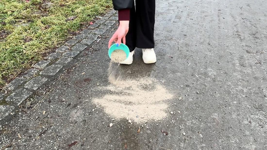 Gołoledź na chodniku posypana popiołem drzewnym zamiast soli, domowy sposób na oblodzony chodnik przed domem